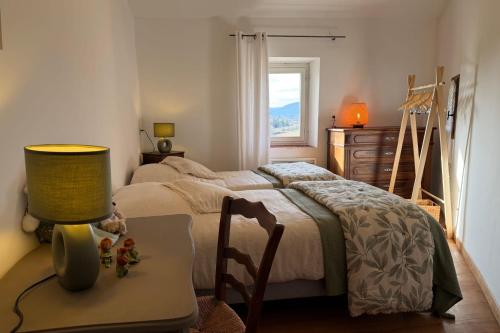 a bedroom with a bed and a table with a lamp at Le Clos Lau-Tave Charming 110 m Provençal home with private garden in Simiane-la-Rotonde