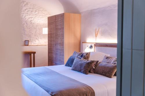 a bedroom with a large white bed with pillows at Hotel Boutique Monells Summum in Monells