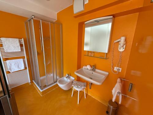 an orange bathroom with a sink and a shower at Garni Franz Leiter in Lagundo