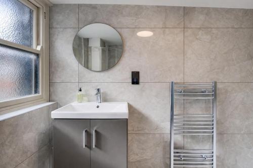 a bathroom with a sink and a mirror at Stylish 2BR Apartment in Leicester Square in London