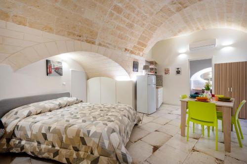 a bedroom with a large bed and a table at Petit Maison Martini ' in Altamura