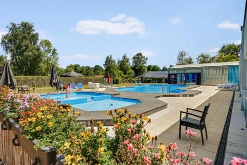 a view of a swimming pool with flowers at De Vecht, 124 - centraal gelegen aan vijver in Gramsbergen