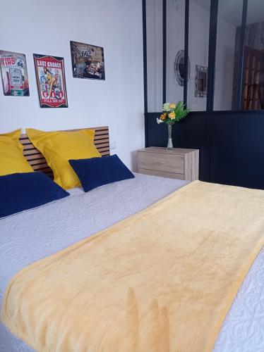 two beds in a bedroom with yellow and blue at Appartement au rez -de -chaussée maison individuelle in Louvigny
