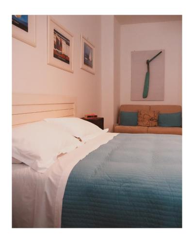 a bedroom with a white bed and a couch at La Foresteria in Mola di Bari