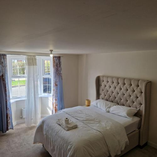 a bed in a bedroom with a large window at Nairn Way House in Kirby Muxloe