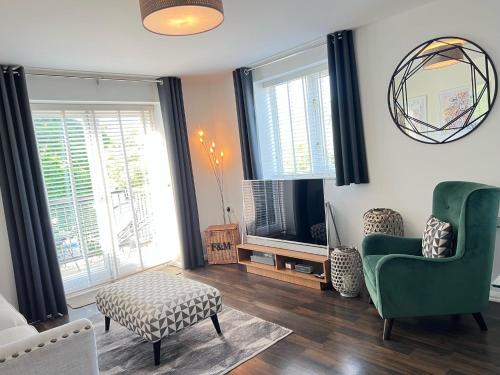a living room with a green chair and a table at 116 The Pond House in Holmfirth
