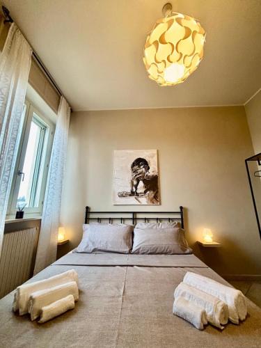 a bedroom with a bed with two towels on the floor at Suite Altura in Cuneo