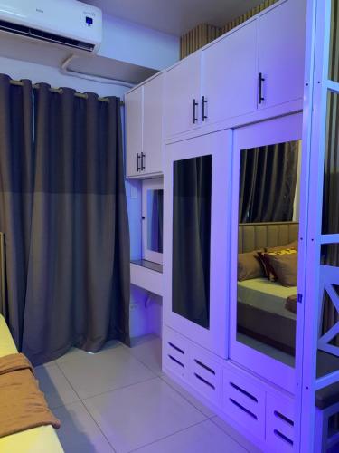 a purple bedroom with a bed and a tv at MOA Prime Staycation Sea Residences in Manila
