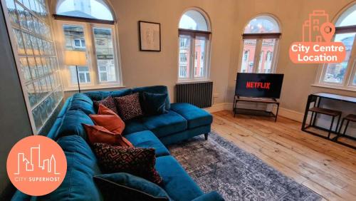 a living room with a blue couch and a television at City Centre Manchester Apt by City SuperHost in Manchester