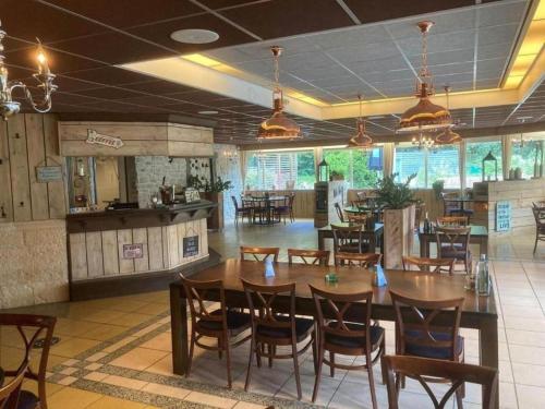 a dining room with wooden tables and chairs at De Vecht, 124 - centraal gelegen aan vijver in Gramsbergen