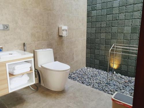 a bathroom with a toilet and a sink and a shower at R7 Cottages Pangandaran in Cikembulan