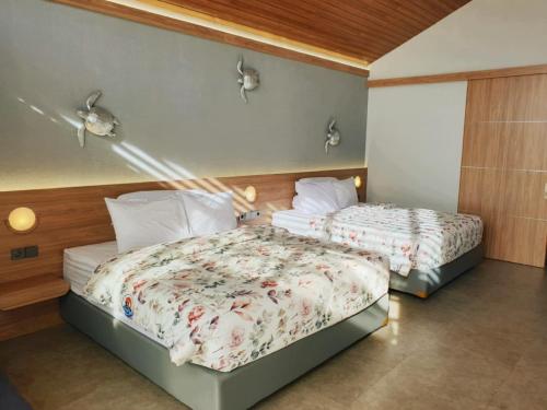 two beds in a hotel room with at R7 Cottages Pangandaran in Cikembulan