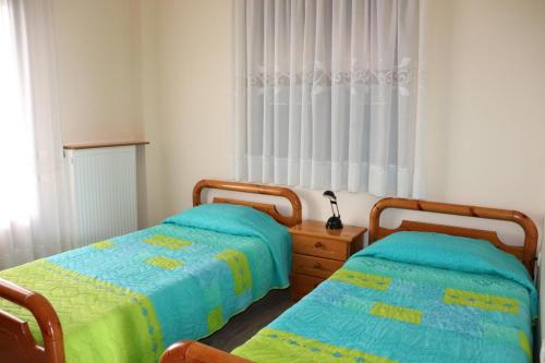two twin beds in a bedroom with a window at El Mar in Kómboi