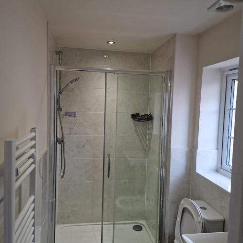 a shower with a glass door in a bathroom at Nairn Way House in Kirby Muxloe