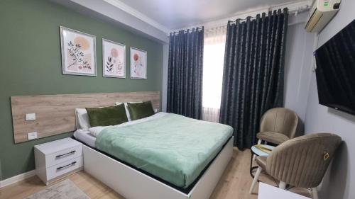 a bedroom with a bed and a chair and a window at Orom Hotel in Dushanbe
