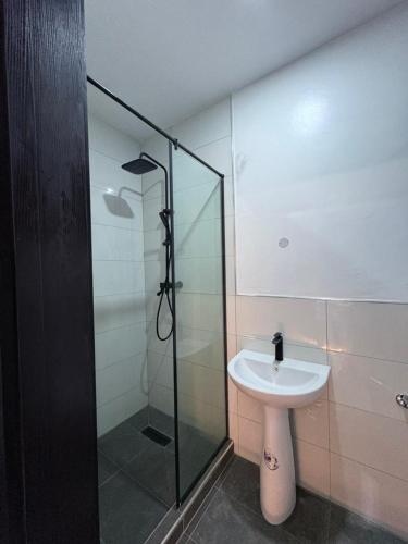 a bathroom with a sink and a glass shower at JKB APARTMENt in Lekki