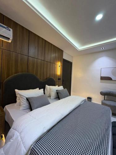 a bedroom with a large white bed with two pillows at JKB APARTMENt in Lekki