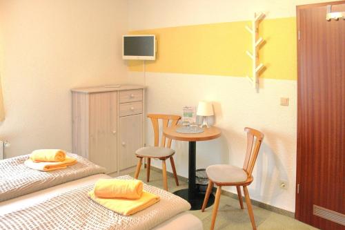 a room with two beds and a table and chairs at Pension An der Kamske - DZ 1 in Lübbenau