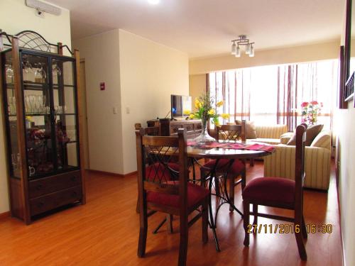 a dining room and living room with a table and chairs at Bonito Apartamento en Miraflores in Lima