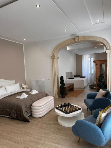 a bedroom with a bed and two blue chairs at Centrale Suites in Brindisi