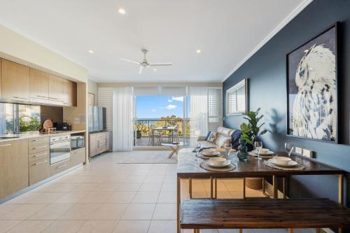 a kitchen with a table and a dining room at Oceanfront Spa Suite - Sub Penthouse in Urangan