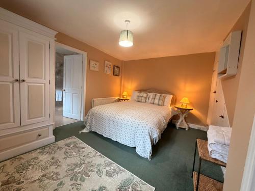 a bedroom with a bed with a white bedspread at Lorash Cottage, Ashbourne in Ashbourne