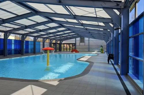 a large pool with a red umbrella in a building at De Gouwe, 158 - aan visvijver, de beste visstek in Gramsbergen