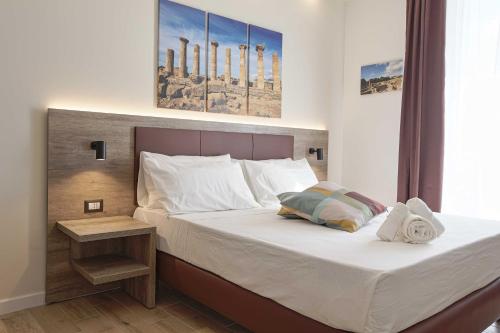 a bedroom with a large bed with a wooden headboard at B&B Sikelia Suite in Agrigento