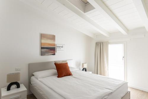 a white bedroom with a bed and a window at Maison Bellini number 3 in Toscolano Maderno