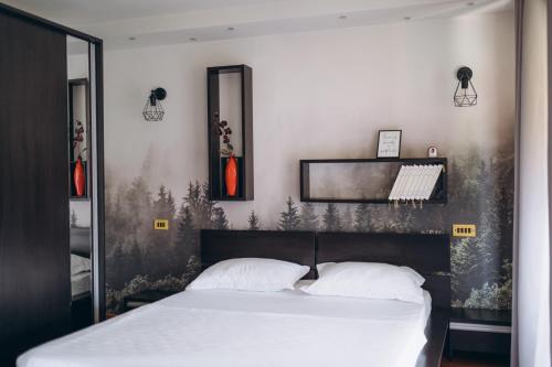 a bedroom with a large bed with white sheets at Casa cu Palmieri in Călimăneşti
