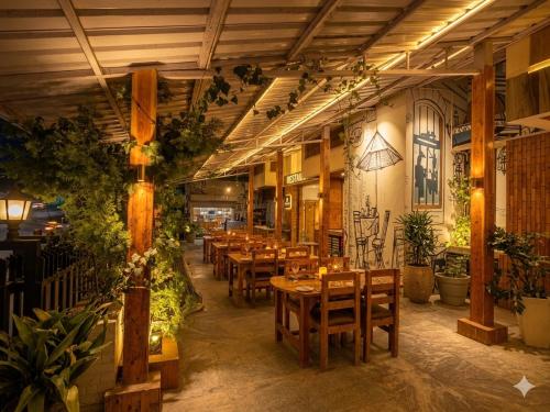 a restaurant with wooden tables and chairs and plants at The Hamilton Valley View, Koti - A Beautiful Resort in Cloud's in Shimla