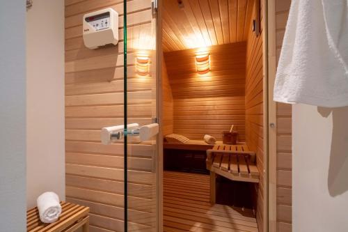 a bathroom with a sauna with wooden walls at Haus an der Koppel in Borgsum