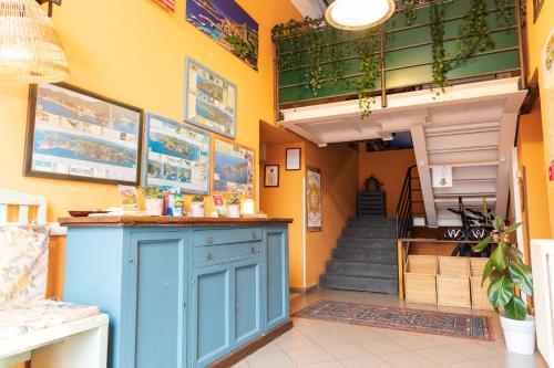 a shop with a blue counter in a room with stairs at Ostello Tramonti in Biassa
