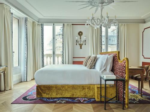 a bedroom with a large bed and a chandelier at Hôtel Aventure in Paris