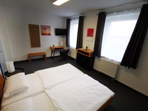 a bedroom with a white bed and a window at Pilotenunterkunft Fliegerhorst in Strausberg