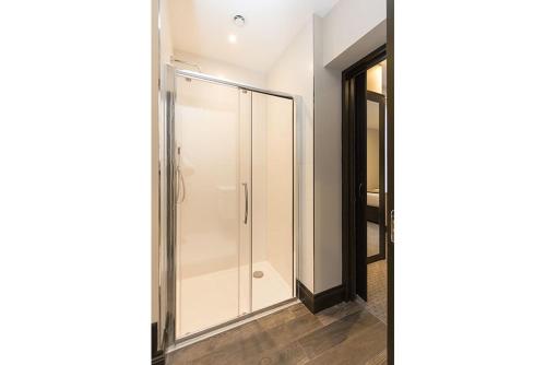 a shower in a bathroom with a glass door at The Westbourne Residences in London