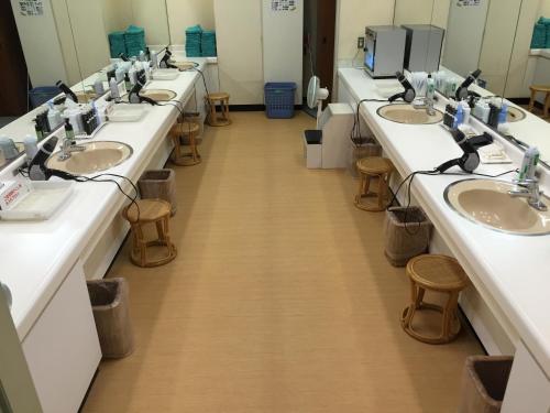 a row of sinks in a public bathroom at Capsule&Spa Grand Sauna Hiroshima (Male Only) in Hiroshima
