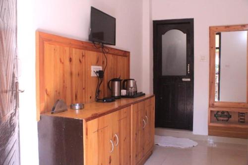a wooden cabinet with a television on top of it at Woodward 2 by 4 Wildflower in Kasol