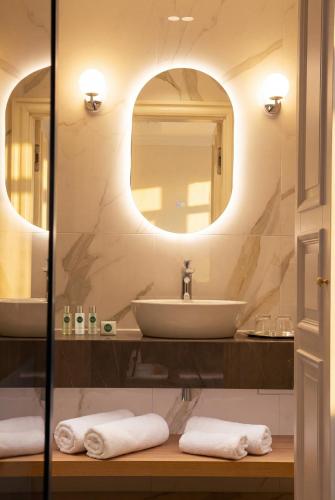a bathroom with a sink and a mirror at Boutique Hotel H23 in Pezinok