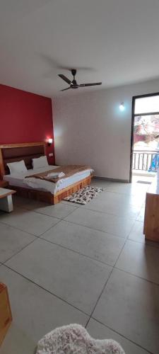 a bedroom with two beds and a red wall at Woodward 2 by 4 Wildflower in Kasol