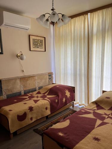 a bedroom with two beds and a window at Garabuczi Apartman in Keszthely