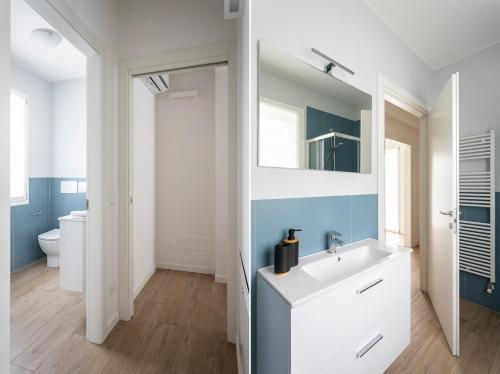 a bathroom with a white sink and a mirror at Maison Bellini 1 in Toscolano Maderno