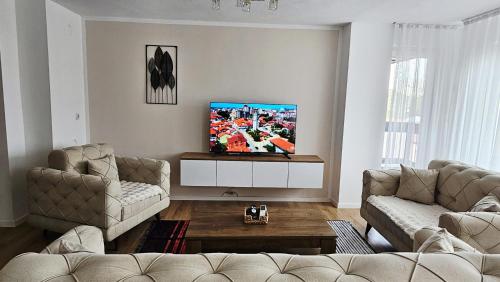 a living room with two couches and a flat screen tv at HTH Apartments in Center of Gjakova - 4th Floor in Gjakove