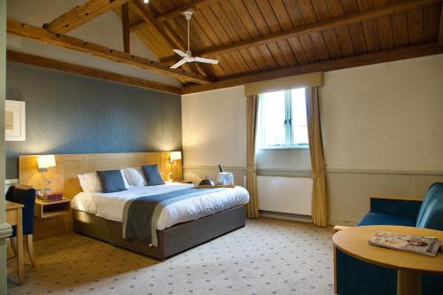 a bedroom with a bed and a ceiling fan at Cambridge Quy Mill Hotel & Spa in Cambridge