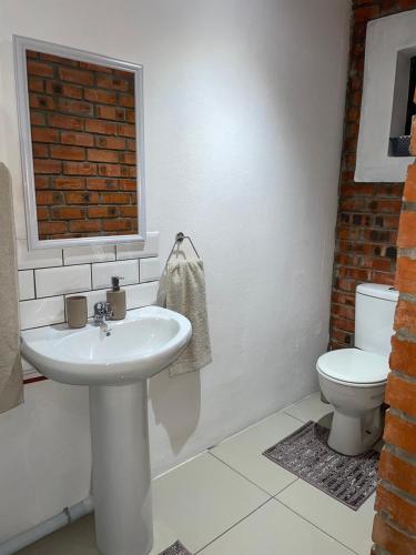 a bathroom with a sink and a toilet at Kubbe Comfort Corner in Bloemfontein
