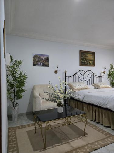 a bedroom with a bed and a coffee table with flowers at Providence Guesthouse and Catering Services in Abidjan