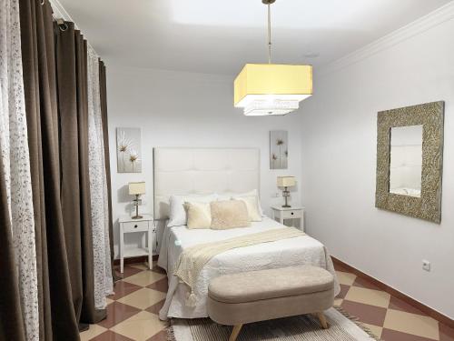 a bedroom with a bed and a chair and a mirror at Casa Miguelín in Montecorto