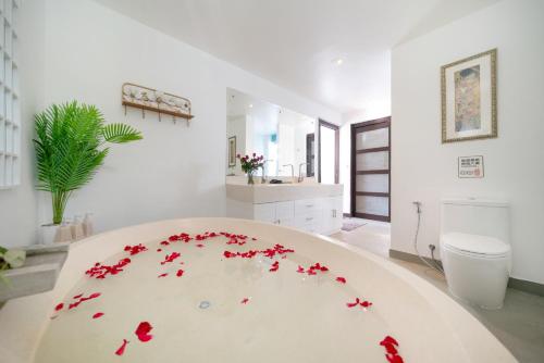 a room with a white table with red flowers on it at Nivara Pool Villa - Rawai in Rawai Beach