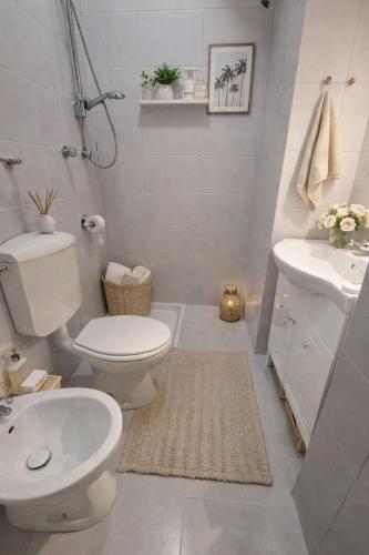 a white bathroom with a toilet and a sink at Appartamento Duomo-Monte Nero in Milan