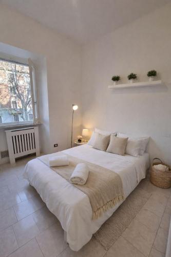 a white bedroom with a large white bed with pillows at Appartamento Duomo-Monte Nero in Milan